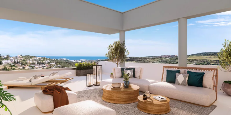 Infografía de una terraza de la promoción de Valle Romano Golf, con sofás y el mar y la sierra al fondo